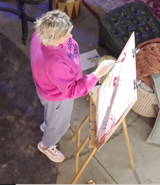 AN DEROOST painting at an easel during a one-to-one atelier session.